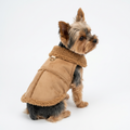 A small beige dog wearing a tan fleece-lined pet coat, shown from behind on a white surface with a gray background.